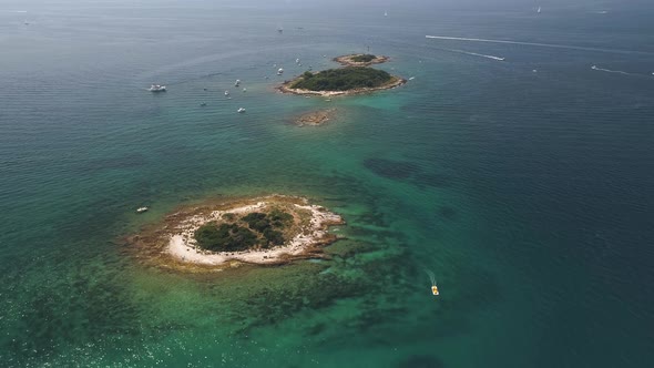 Boats moored near two tiny islands in Adriatic Sea