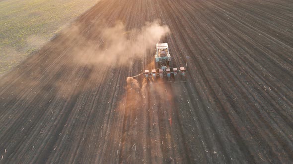 Aerial View of Farmer with Old Tractor Seeding Sowing Crops at Agricultural Fields