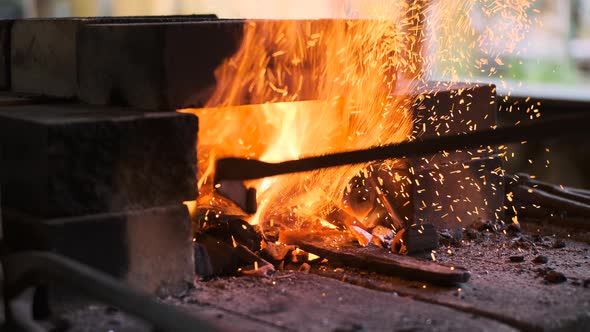 Worker in Forge Tosses Coal Into Furnace to Heat Iron