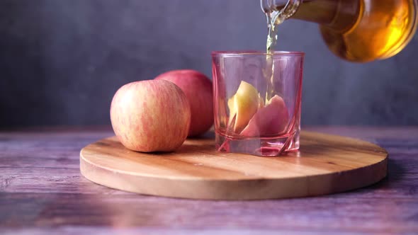 Apple Vinegar in Glass Bottle with Fresh Green Apple on Table