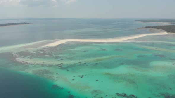 Aerial: tropical beach island reef caribbean sea white sand bar Snake Island, Indonesia Maluku