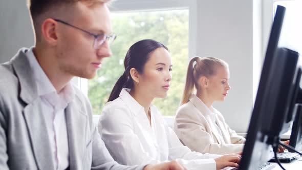 Diverse team of young professionals is working in the phone support office.