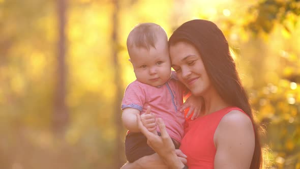 Smiling Mother with Baby on Sunset