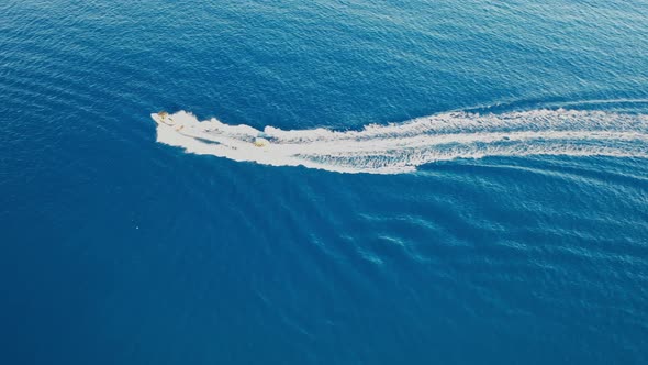Aerial View of a Motor Boat Towing a Tube. Elounda, Crete, Greece