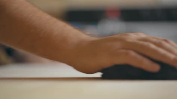 slow motion static shot of a man sanding a wooden table with a sanding block