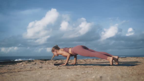 Young Woman Doing Stretching and Yoga Exercise on Ocean Beach Slow Motion