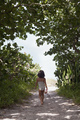 Rear view of girl wearing bathing costume walking along woodland beach path, Anna Maria Island, - PhotoDune Item for Sale