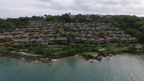 Flight of a Drone Over a Village on the Seashore