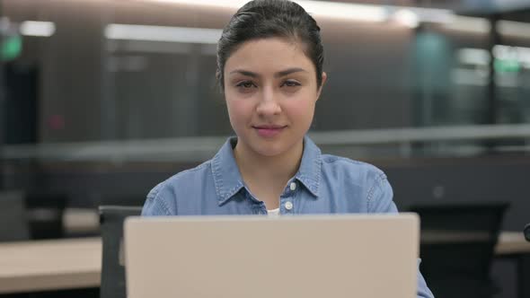 Close Up of Indian Woman Smiling at Camera While Using Laptop