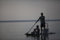 Silhouetted man and  teenage son fishing from paddleboard in Lake Superior, Au Train Bay, Michigan, - PhotoDune Item for Sale