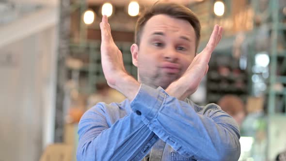 Portrait of Casual Man Crossing Arms As Rejection Sign