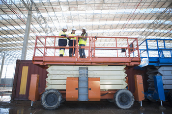 Low angle view of site managers and architect on viewing platform on construction site