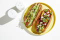 Two garnished hotdogs on yellow plate, overhead still life - PhotoDune Item for Sale