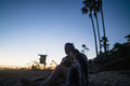 Romantic young couple sitting on beach watching sunset, Newport Beach, California, USA - PhotoDune Item for Sale