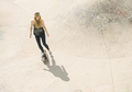 High angle of young female skateboarder skateboarding in skatepark - PhotoDune Item for Sale