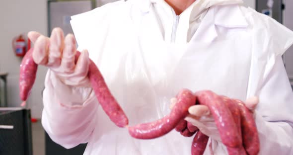 Female butcher holding sausages