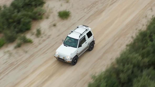 Aerial View of a Car Driving on Sand