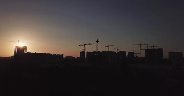 Takeoff of the Drone Against the Backdrop of the Sunset and the Silhouette of Houses Under