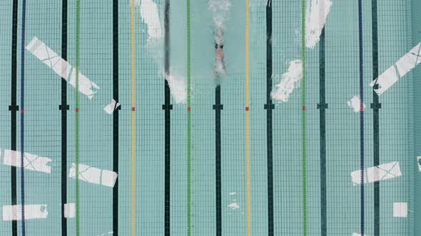 A top view od a sportman swimming in an olympian swimming pool