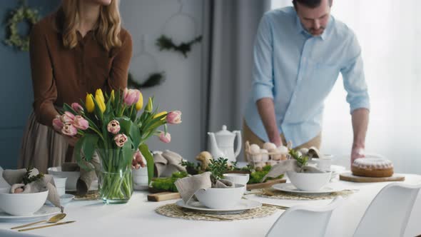 Caucasian couple preparing  table for easter dinner. Shot with RED helium camera in 8K.