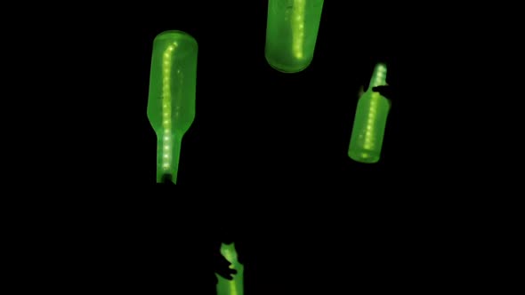 Green luminous Bottles Spin in the Air in Total Darkness Abstract Holiday Show Concept