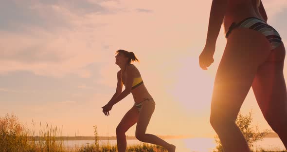 Beach Volleyball Match Girls Hit the Ball in Slow Motion at Sunset on the Sand.