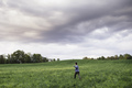 Boy walking on green grassy field - PhotoDune Item for Sale