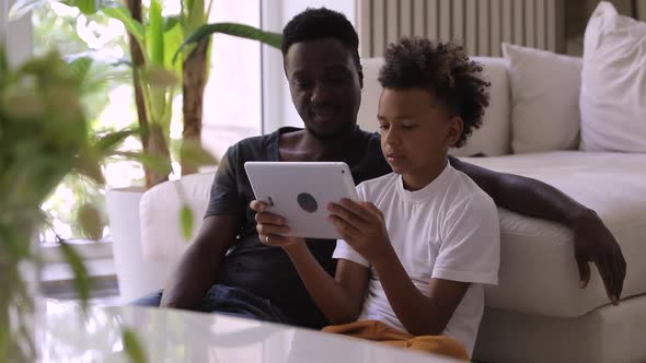 Teenager African Boy Son Showing Dad Movie on Tablet Spbi