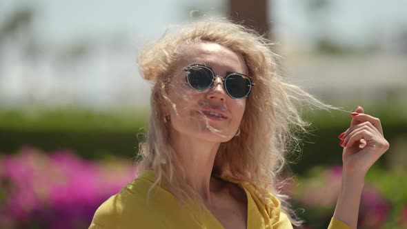 Portrait of a Blonde in Sunglasses and a Yellow Dress