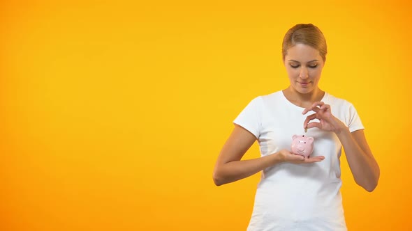 Positive Female Putting Coin in Piggybank, Planning Budget, Financial Savings