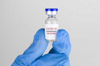COVID-19. Coronavirus Vaccine concept in hand of doctor blue vaccine jar. Vaccine Concept of fight against coronavirus.