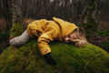 Little Smiling Blonde Child Lying and Hugging a Mossy Stone in Autumn Forest - PhotoDune Item for Sale