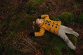 Portrait of Little Blonde Girl in Yellow Coat Lying on the Ground in the Autumn Forest - PhotoDune Item for Sale
