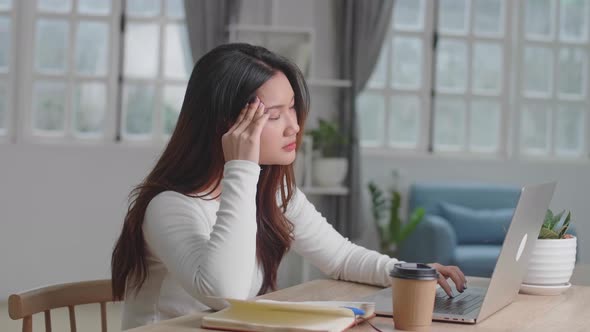 Stressed Young Asian Girl Working On Laptop Computer At Home