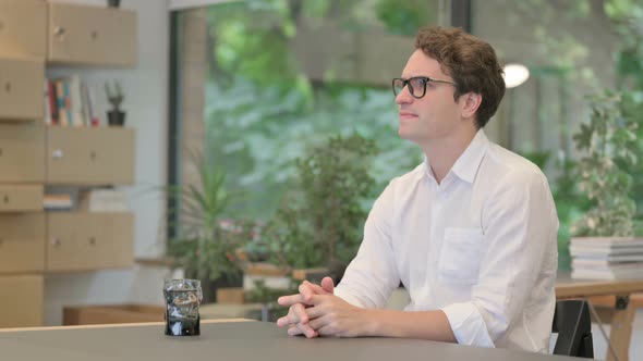 Young Man Feeling Worried While Sitting in Office