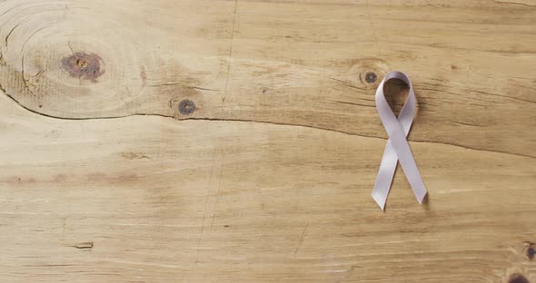 Video of white lung cancer ribbon on wooden background