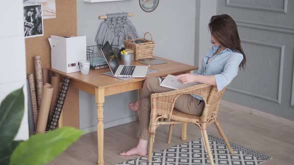 Freelancer Reads Magazine in Home Studio