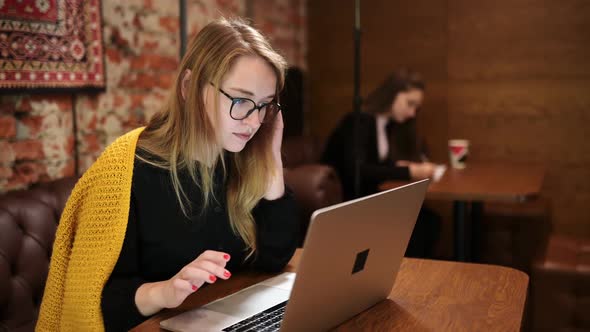 Young and Beautiful Small Business Owner is Working on Laptop Computer and Checking Inventory in a