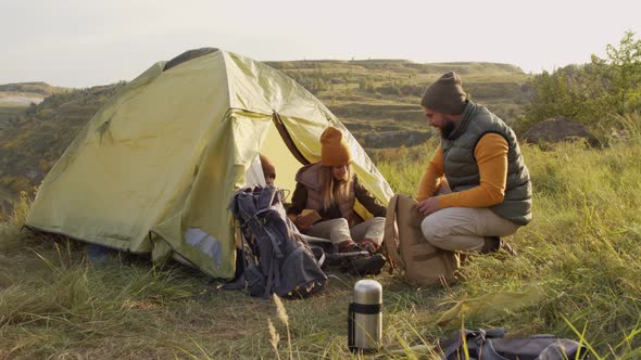 Family of Three Camping on Hill