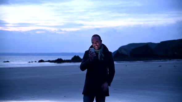 Man at beach talking on mobile phone