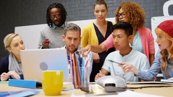 Business executives discussing over laptop in meeting