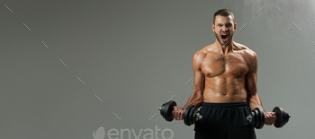 Website header of Exited handsome bodybuilder with powerful torso building up muscles with dumbbells