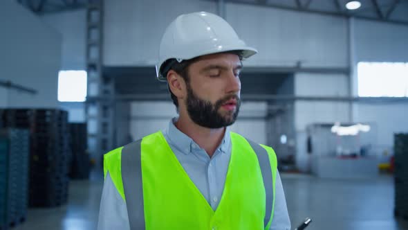 Uniform Storage Worker Inspecting Boxes Before Shipment Wearing White Helmet