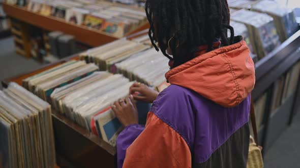 Rear View of Young Woman Looking Through Vinyl Records