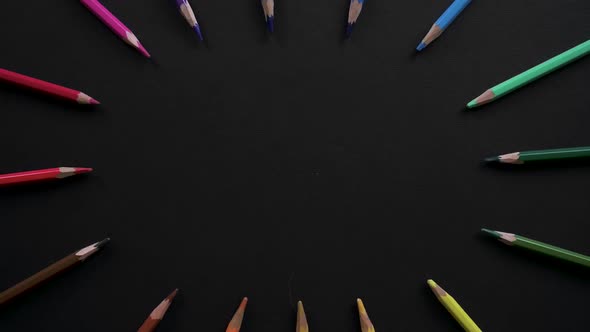 Wooden School Pencils of Different Colors Are Located on the Black Surface. Stop Motion Animation