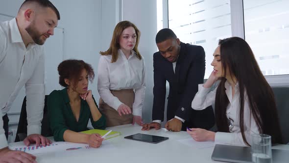 Multiethnic Startup Team Discussing Progress at Meeting