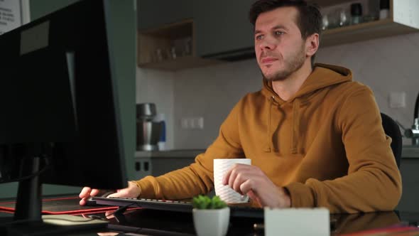 Man Works at Home Office Remotely Using Computer