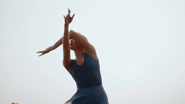 Woman Performs Ballet Movements with Her Hands Background Sky Bottom View