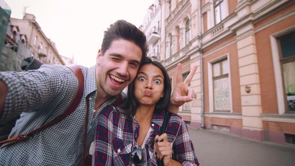 POV of the Young Mixed Race Tourist Couple Taking Selfie in Old City Center and Having Some Fun