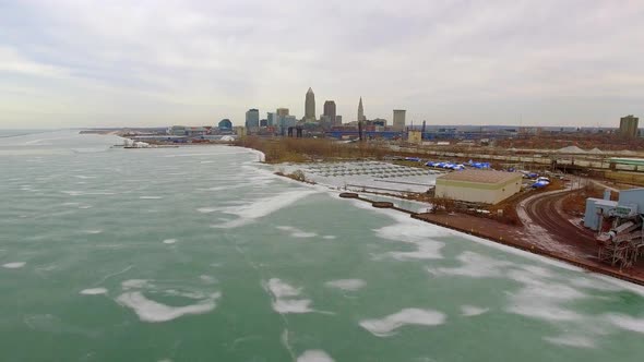 Wide revealing drone shot of downtown Cleveland Ohio and a frozen Lake Erie